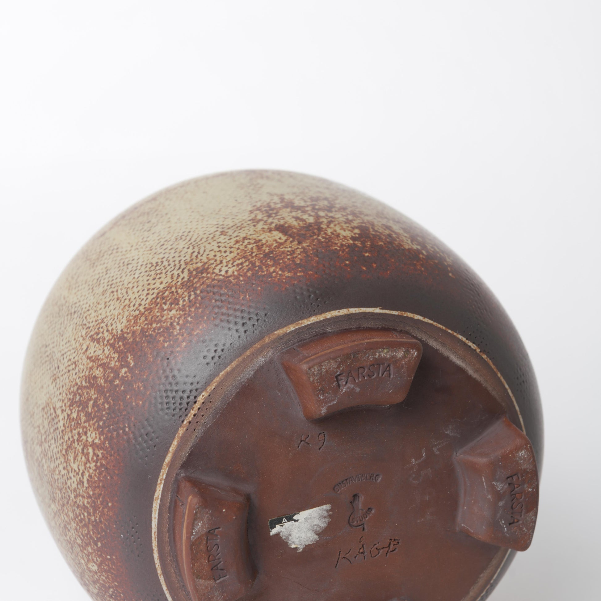 Urna i stengods, Farsta, av Wilhelm Kåge 1960 för Gustavsberg. Signerad Gustavsberg Kåge K9 FARSTA samt Studiohanden. 21cm hög och diameter 18cm. Farsta stoneware lidded urn by Wilhelm Kåge 1960 for Gustavsberg. Signed Gustavsberg Kåge FARSTA K9 and the “Studio hand”. H: 21cm/8,3″ and diam. 18cm/7,1