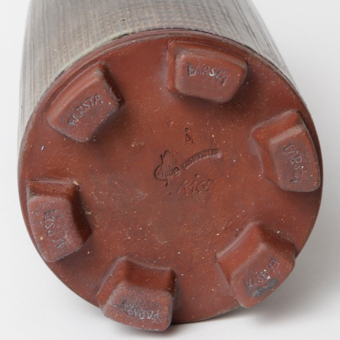 Farstavas i stengods, av Wilhelm Kåge 1956 för Gustavsberg i jordfärger med ristad struktur. Signerad GUSTAVSBERG KÅGE Å samt FARSTA. 34,5cm hög och diameter 11,5cm. Farsta vase in stoneware, by Wilhelm Kåge 1956 for Gustavsberg. H: 34,5cm/13,6″ and diam. 11,5cm/4,5". Signed Gustavsberg KÅGE Å Farsta.