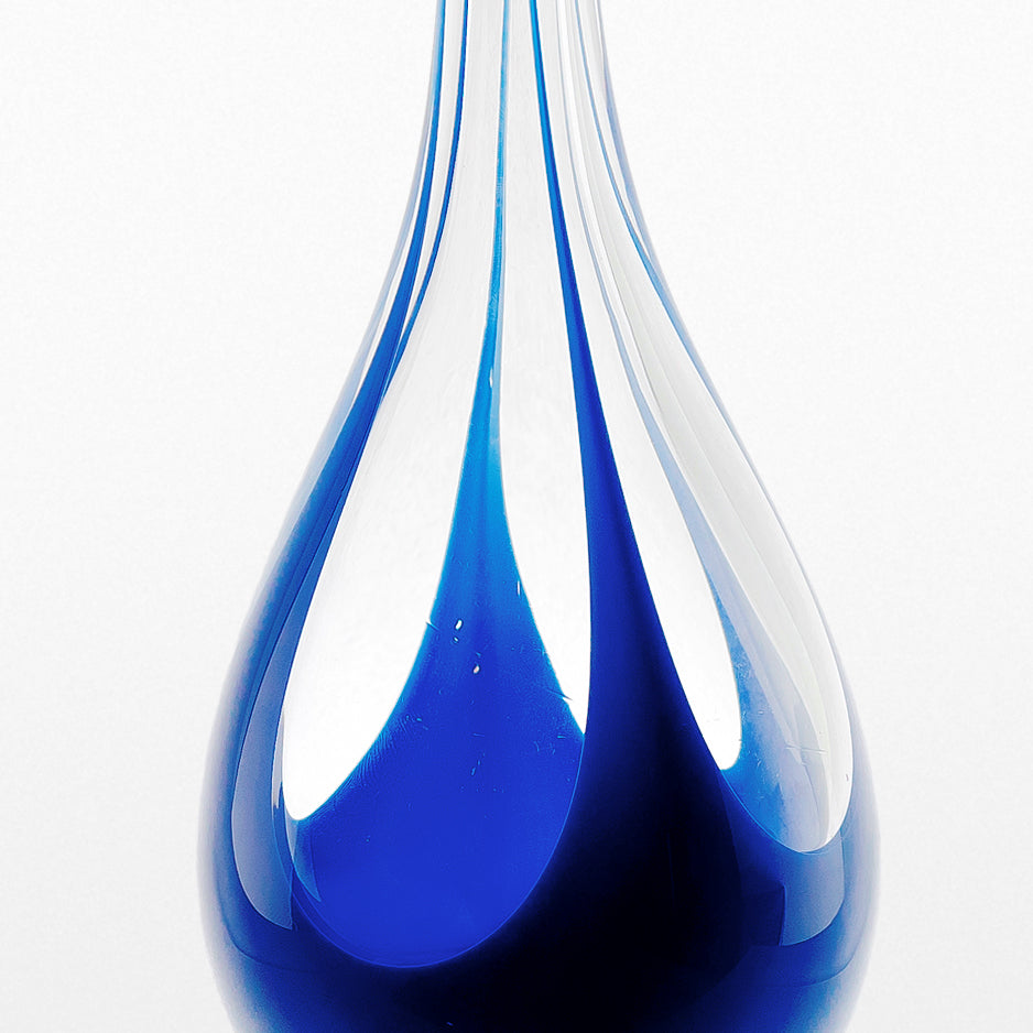Vas från Kosta i klarglas med blått underfång. Signerad LH 1193 LINDSTRAND KOSTA. 35,5cm hög. Kosta vase with blue underlay. H: 35,5cm/14″. Signed LH 1193 LINDSTRAND KOSTA.