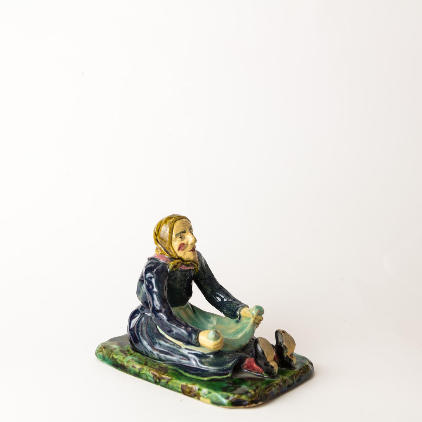 Figurin Påltorperskan från Höganäs, ca 1900. H: 12,5cm, L: 16,5cm. Märkt 7. G. 7. HÖGANÄS KH. Figurin "Påltorperskan" by Höganäs around 1900. H: 12,5cm/4,9" and W: 16,5cm/6,5". Marked 7. G. 7. HÖGANÄS KH.