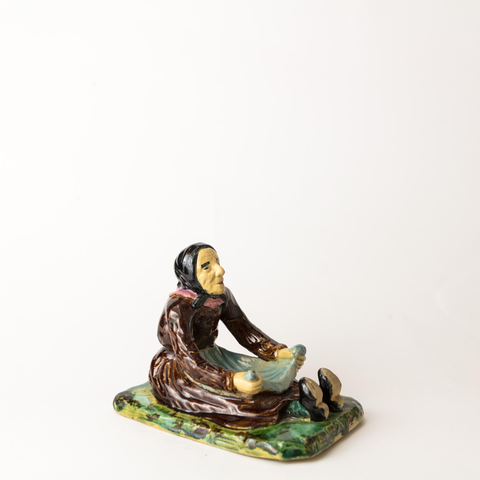 Figurin Påltorperskan från Höganäs, ca 1900. H: 12,5cm, L: 16,5cm. Märkt 7. G. 7. HÖGANÄS KH. Figurin ”Påltorperskan” by Höganäs around 1900. H: 12,5cm/4,9″ and W: 16,5cm/6,5″. Marked 7. G. 7. HÖGANÄS KH.