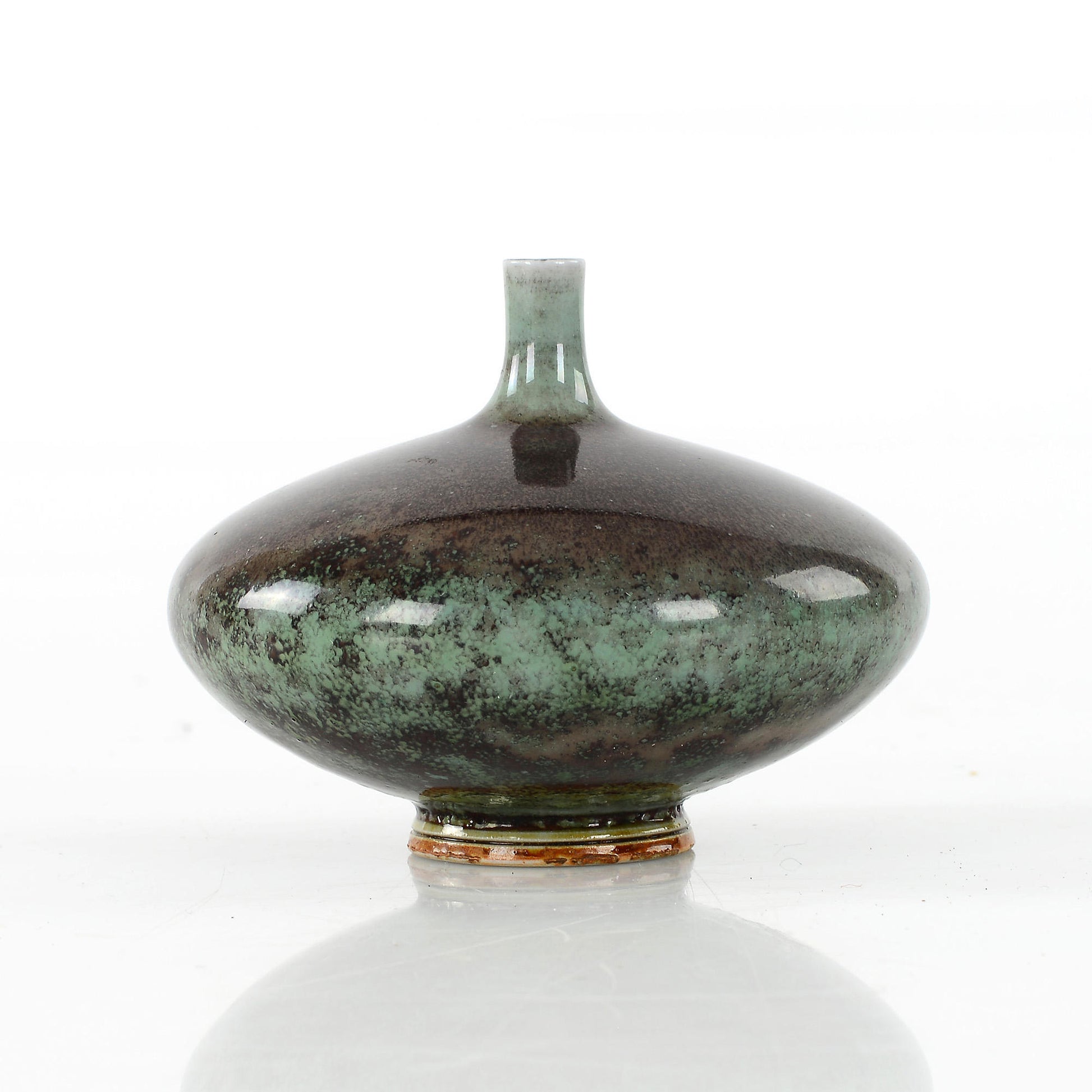 Stengodsvas diskus från Gustavsberg av Berndt Friberg med blank aniaraglasyr. 5,8cm hög och diam. 8cm Stoneware vase, discus shaped, by Berndt Friberg for Gustavsberg with glossy Aniara glaze. H: 5,8cm/2,3″ and diam. 8cm/3,1″