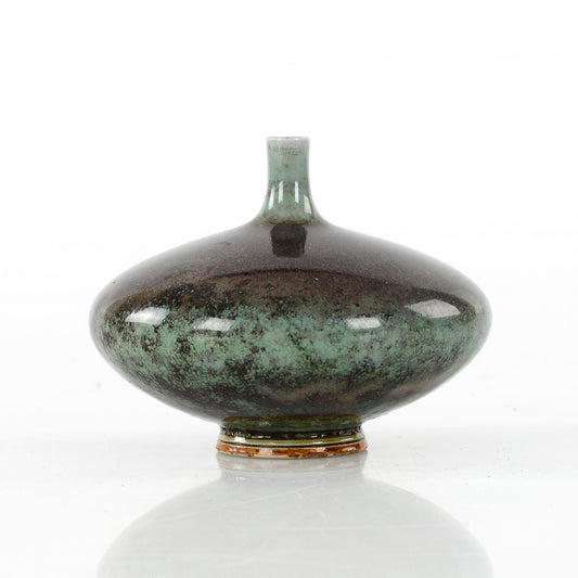 Stengodsvas diskus från Gustavsberg av Berndt Friberg med blank aniaraglasyr. 5,8cm hög och diam. 8cm Stoneware vase, discus shaped, by Berndt Friberg for Gustavsberg with glossy Aniara glaze. H: 5,8cm/2,3″ and diam. 8cm/3,1″