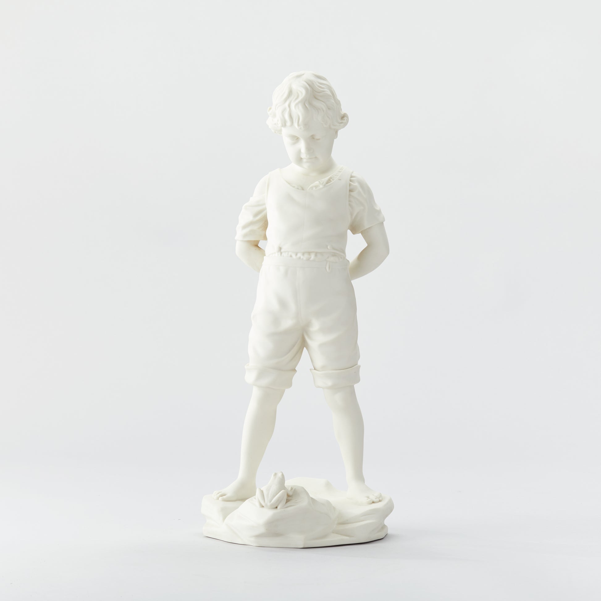 Parianfigurin från Gustavsberg, ”Pojken och Grodan”. 51cm hög. Märkt Gustavsberg och tillverkningsåret 04. Parian figurine, ”Boy and the Frog” by Gustavsberg. H: 51cm/20,1″. Marked Gustavsberg 04.
