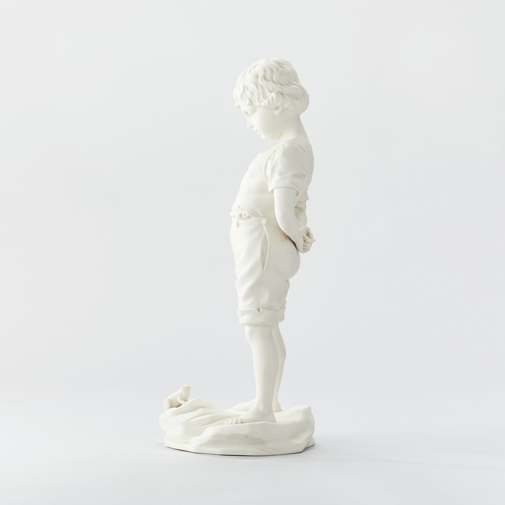 Parianfigurin från Gustavsberg, ”Pojken och Grodan”. 51cm hög. Märkt Gustavsberg och tillverkningsåret 04. Parian figurine, ”Boy and the Frog” by Gustavsberg. H: 51cm/20,1″. Marked Gustavsberg 04.