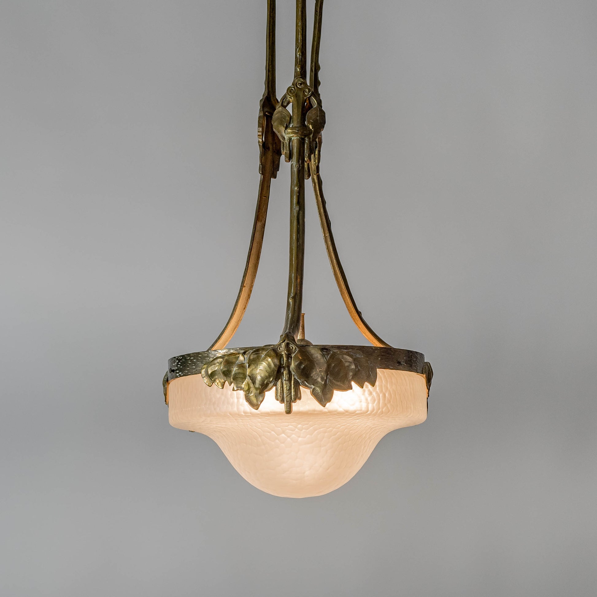 Jugendtaklampa i guldpatinerad brons från Böhlmarks, 1910-tal. 80cm hög och diam. 40cm. An art nouveau ceiling light in bronze. Made by Böhlmarks around 1910. H: 80cm/31,5″ and diam. 40cm/15,7″