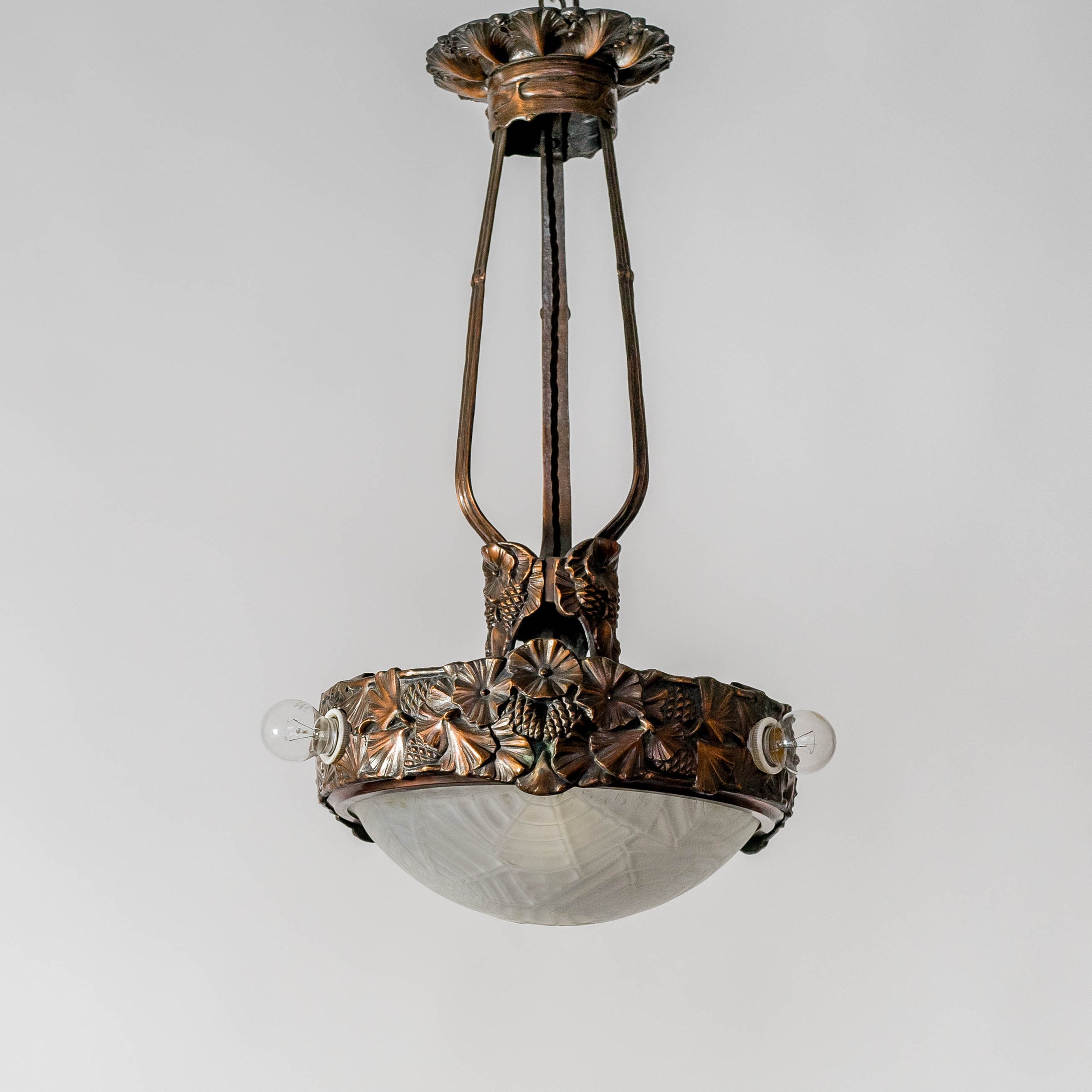 Jugendtaklampa i kopparpatinerad brons från Böhlmarks, 1910-tal. 65cm hög och diam. 35cm. An art nouveau ceiling light in bronze. Made by Böhlmarks around 1910. H: 65cm/25,6″ and diam. 35cm/13,8″