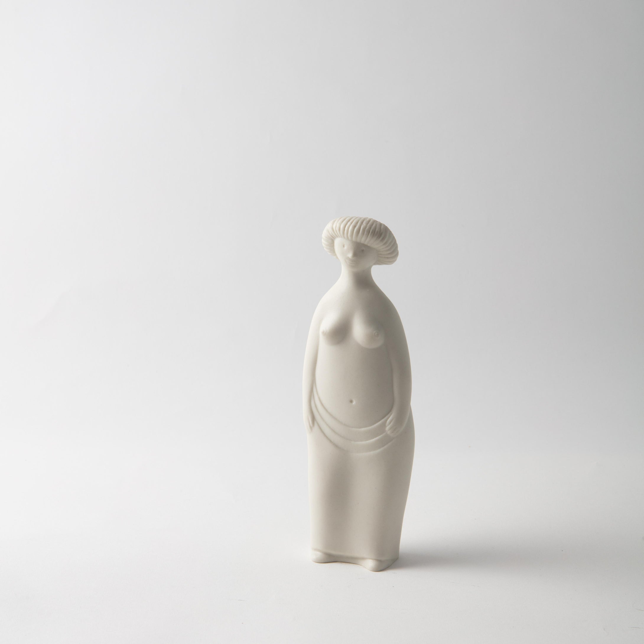 Figurin i parian av Stig Lindberg för Gustavsberg, 1960-tal. Serien heter ”Figurin” och detta är ”Lilla Eva”. Höjd 18,5cm. Stig Lindberg parian figurine ”Lilla Eva” for Gustavsberg in the ”Figurin” series, 1960’s. H: 18,5cm/7,3″
