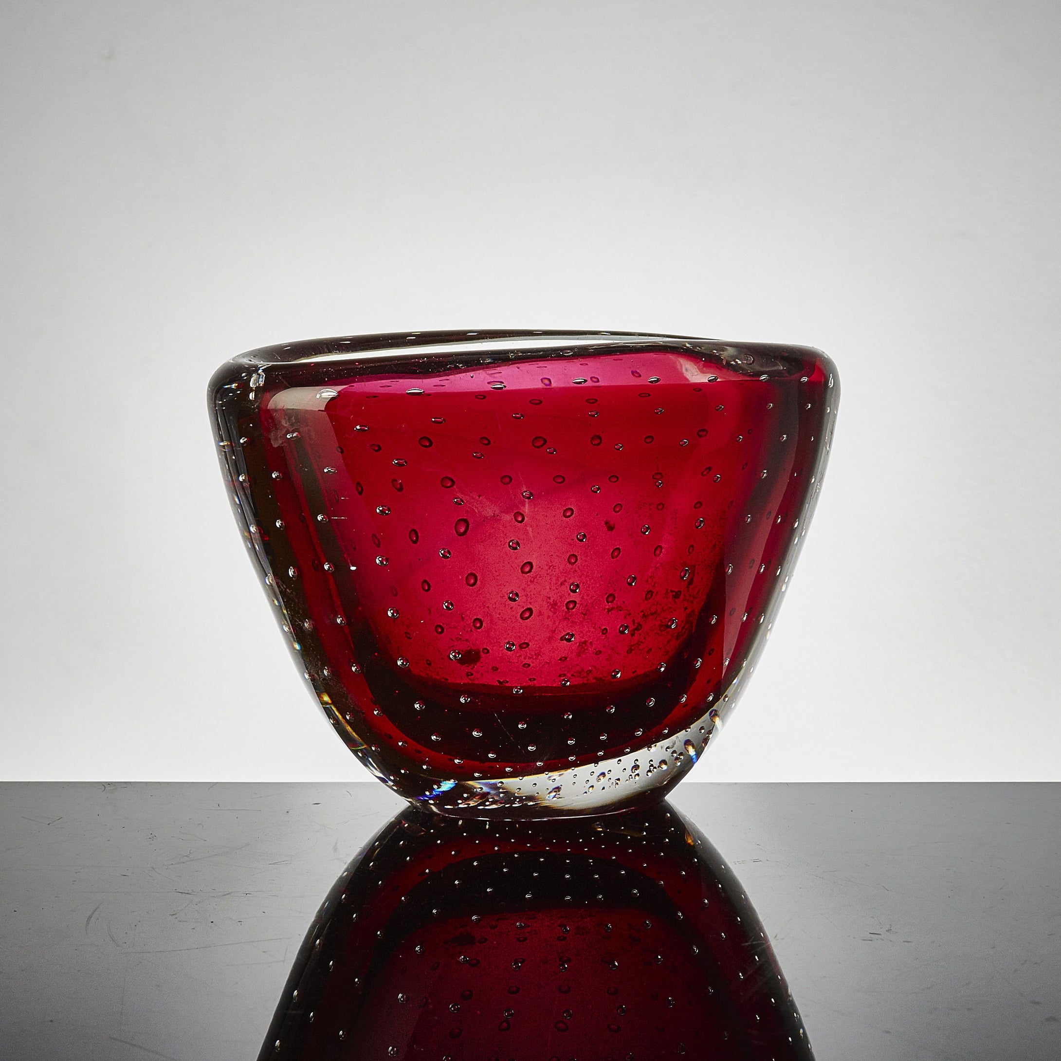 Vas av Vicke Lindstrand för Kosta i klarglas rött underfång. Signerad LH 1329. 11,5cm hög och 17cm bred. Kosta vase by Vicke Lindstrand with red underlay. H: 11,5cm/4,5″ and W: 17cm/6,7